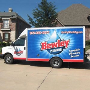 Bewley Plumbing box truck in front of a residential street with beautiful homes behind it