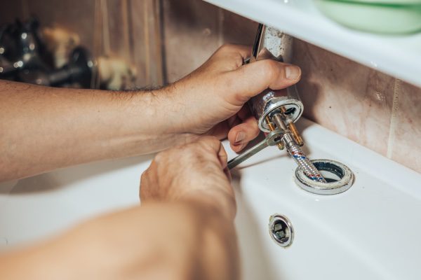 A plumber replacing a sink fixture.
